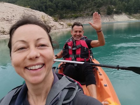 Group of kayaks sailing in silence on the reservoir surrounded by green mountains